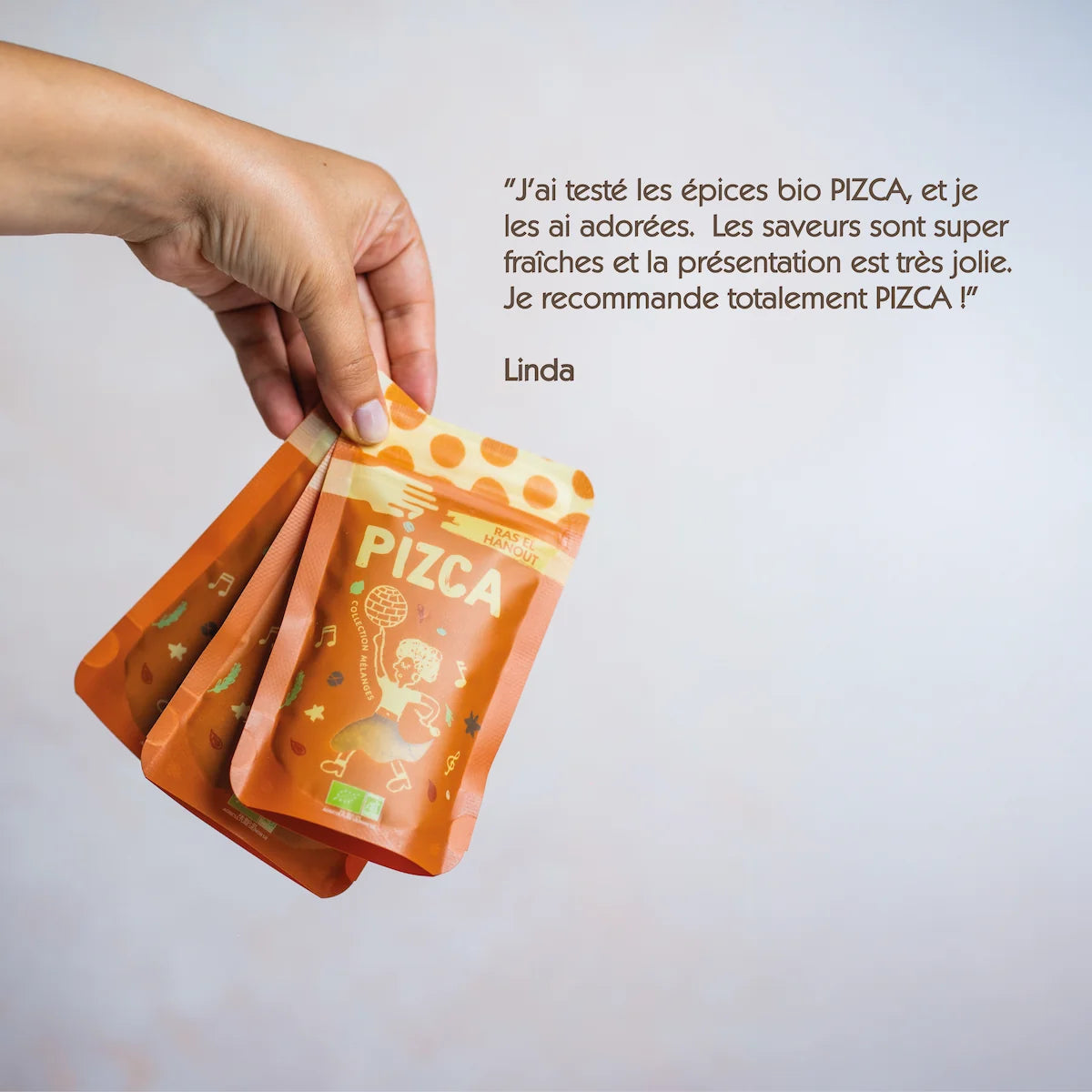 Témoignage client positif sur le coffret mélanges d'épices bio de Pizca avec trois sachets mélanges tenus à la main.